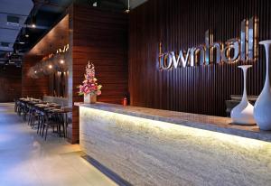 a restaurant with a counter with tables and vases at Midtown Hotel Surabaya in Surabaya
