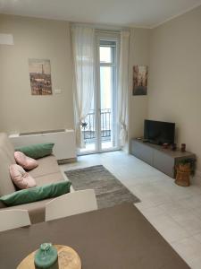 uma sala de estar com um sofá e uma televisão em Residenza Il principe, Bilocale 2 in centro em Parma
