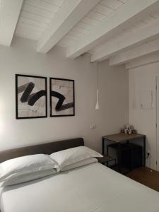 奇維達萊德爾夫留利的住宿－Borgo di Ponte Holiday Apartments & Rooms，卧室配有白色的床和墙上的两张照片