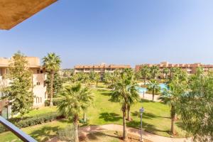 Escale de Charme - Prestigia Golf - Vue piscine في مراكش: اطلالة على حديقة فيها نخل ومباني