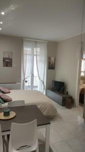 Schlafzimmer mit einem Bett, einem Tisch und einem TV in der Unterkunft Residenza Il principe, Bilocale 2 in centro in Parma