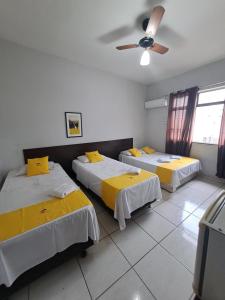 a room with two beds and a ceiling fan at Hotel Panorama, Cuiabá in Cuiabá