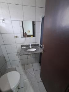 a bathroom with a toilet and a sink and a mirror at Hotel Panorama, Cuiabá in Cuiabá