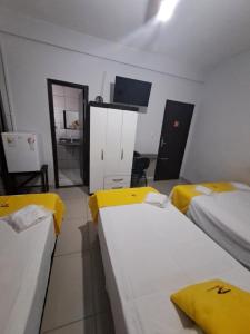 a room with two beds with yellow sheets at Hotel Panorama, Cuiabá in Cuiabá