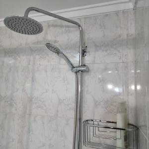 łazienka z prysznicem z głowicą prysznicową w obiekcie Apartamentos Paz Ribadeo w mieście Ribadeo