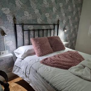 sypialnia z łóżkiem z różowymi poduszkami w obiekcie Apartamentos Paz Ribadeo w mieście Ribadeo