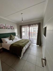een slaapkamer met een groot bed en een groot raam bij 1152 @The Blyde Riverwalk - Crystal Lagoon in Pretoria