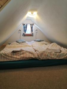 Bett im Dachgeschoss mit Fenster in der Unterkunft Apartmán Dvě Micky in Pec pod Sněžkou