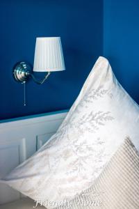 a blue wall with a lamp and a white pillow at Friendly Home - Einzelappartement "Trust" Köln Bonn Phantasialand in Brenig
