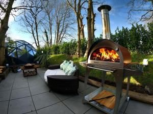 a pizza oven sitting on top of a patio at Romance - Stargazing - Hot tub & sauna! in Camborne