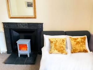 a bed with a fire place next to a fireplace at Catcune Superior Suite in Gorebridge
