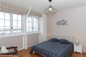 1 dormitorio con 1 cama azul y 2 almohadas en La Grève du Portrieux, en Saint-Quay-Portrieux