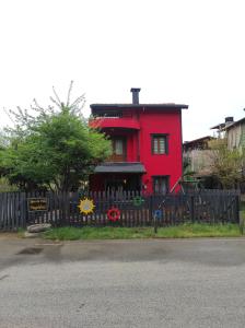 a red house with a black fence in front of it at Ağva'da Villa in Sile