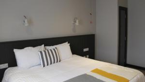 a bed with a black headboard and white pillows at Marine Hotel Ballycastle in Ballycastle