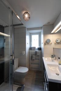a bathroom with a toilet and a sink and a shower at La Grève du Portrieux in Saint-Quay-Portrieux