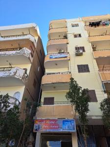 a tall building with balconies on the side of it at Sweet Home Hostel - ممنوع للبنات فى الوقت الحالى in Hurghada