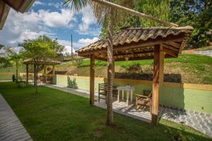 einen hölzernen Pavillon mit einem Tisch und einer Bank im Hof in der Unterkunft Pousada Ventos de Outono in São Roque