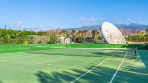 una red de tenis en una pista de tenis con montañas al fondo en Summer House, Golf del Sur en San Miguel de Abona