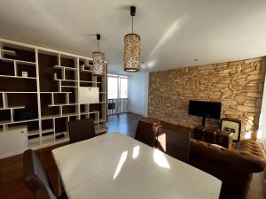 a dining room with a table and a stone wall at No podrás olvidarlo in Baiona