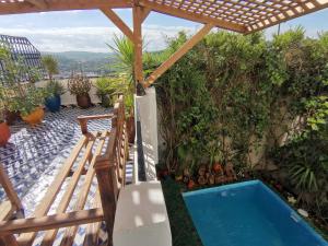 un patio trasero con piscina y sombrilla en Dar Ben Daoud avec piscine et terrasse privee, en Fez