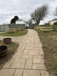 a walkway with two benches in a park at The Pickwick Inn in Kingsbridge +7 photos