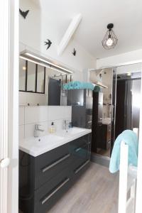 baño con lavabo y espejo grande en La Grève du Portrieux, en Saint-Quay-Portrieux
