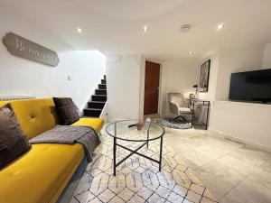 uma sala de estar com um sofá amarelo e uma mesa de vidro em Quirky 3 Bedroom Town House in Clifton, Bristol em Bristol