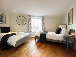 1 Schlafzimmer mit 2 Betten und einem Spiegel in der Unterkunft Quirky 3 Bedroom Town House in Clifton, Bristol in Bristol