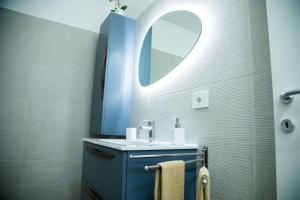 a bathroom with a blue sink and a mirror at STUDIO 47 - CITY LIFE in Milan