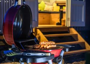 a grill with some food on top of it at Nutkins Luxury Shepherd Hut with hot tub close to Lyme Regis in Uplyme