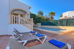 a villa with a swimming pool and two lounge chairs at Monte Rosa in Jávea