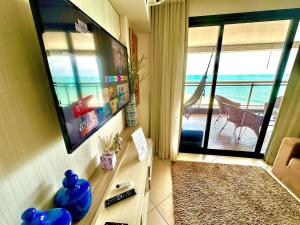 a living room with a flat screen tv on a wall at LANDSCAPE - Beira mar platinum in Fortaleza