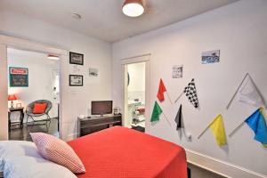 デイトナビーチにあるRetro-Style Studio in Historic Downtown Home!の赤いベッドと壁に旗が飾られた寝室