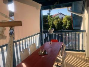 una mesa de madera con copas de vino en el balcón en Bidart côte basque T3 250 mètres de la plage 3***, en Bidart