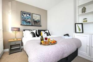 a bedroom with a bed with a tray of fruit on it at Berrywood House - Close to Northampton Town Centre - Free Parking, Fast Wifi, SmartTV with Netflix by Yoko Property in Northampton