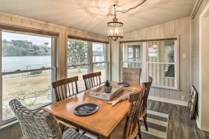 uma sala de jantar com mesa, cadeiras e janelas em Lake Hamilton Family Escape with Kayaks, Dock, Grill em Hot Springs