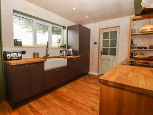 una cucina con armadi neri e pavimenti in legno di Oak Meadow a Hastings