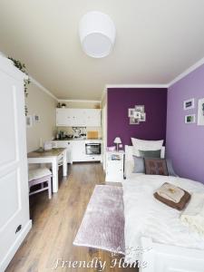 BrenigにあるFriendly Home - Einzelappartement "Calm" Köln Bonn Phantasialandの紫の壁のベッドルーム1室、ベッド1台(テーブル付)