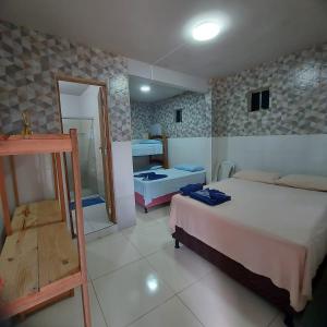 a bedroom with two beds and a mirror at Suítes good trip Itacare sem estacionamento in Itacaré