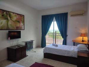 Schlafzimmer mit einem Bett, einem TV und einem Fenster in der Unterkunft Sofea Inn Bukit Merah - Suria A7727 in Kampong Selemat