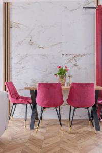 a table and two pink chairs in a room at Folk Vibe in Białka Tatrzanska