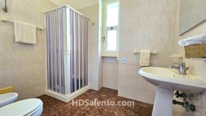 a bathroom with a sink and a toilet and a mirror at Casa Lores - Fronte Mare Pescoluse in Marina di Pescoluse +4 photos