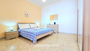 a bedroom with a bed and two dressers in it at Casa Lores - Fronte Mare Pescoluse in Marina di Pescoluse