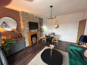 een woonkamer met een tafel en een open haard bij Lovely 1-bedroom serviced apartment in Falmouth in Falmouth