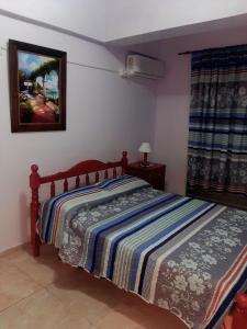 - une chambre avec un lit et une couverture rayée dans l'établissement Apartamentos El Mirador, à El Carmen