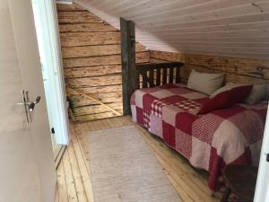 1 dormitorio con 1 cama en una cabaña de madera en Mysig lantlig stuga, Nycklarör, en Korsberga