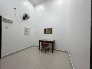 Cette chambre comprend une table et une chaise rouge. dans l'établissement One's Homestay, à Seri Manjung