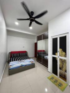 a room with two beds and a ceiling fan at One's Homestay in Seri Manjung