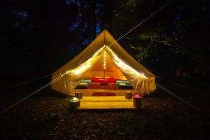 a yellow tent with a bed in the dark at Camp Ćuk 