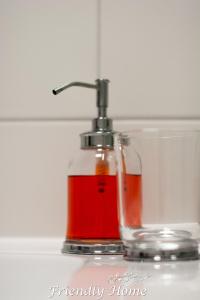 een glazen fles met een rode vloeistof erin bij Friendly Home - Einzelappartement "Calm" Köln Bonn Phantasialand in Brenig